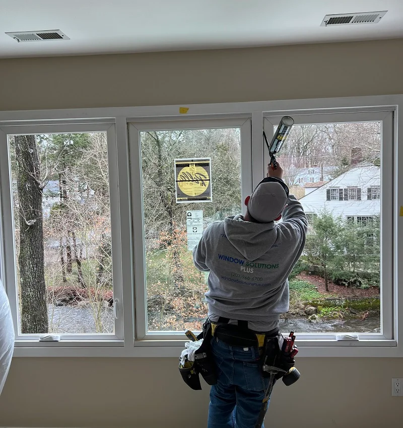 Window Solutions Plus master installer using OSI Quad spray foam to insulate these Pella 250 casement window in Norwalk, CT
